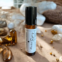 Load image into Gallery viewer, Amber Gypsy perfume oil in 10ml amber glass roll-on bottle styled with golden resin and natural stone accents.