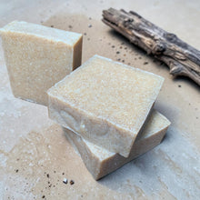 Load image into Gallery viewer, Bali coconut citrus cold process soap with walnut shell exfoliation displayed on a warm sand-toned surface with weathered driftwood