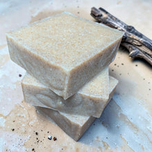 Load image into Gallery viewer, Bali coconut citrus cold process soap with walnut shell exfoliation and creamy aloe vera formula on a sand-toned surface