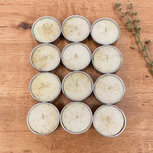 Load image into Gallery viewer, Botanical soy tealights 12 count arranged on warm natural wood surface with dried botanical sprig for Vintage Alchemy