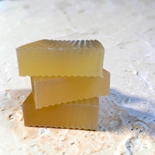 Load image into Gallery viewer, Stacked bars of Cognac glycerin soap on a light stone surface with warm amber tones
