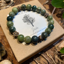Load image into Gallery viewer, jade beaded bracelet with flower charms sitting on gift box
