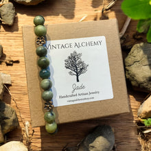 Load image into Gallery viewer, jade stretch bracelet with flower charms sitting on gift box
