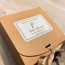Load image into Gallery viewer, Palo Santo smudge stick gift box by Vintage Alchemy on light wood tabletop with kraft packaging and ribbon tie
