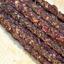 Load image into Gallery viewer, Rose Garden botanical incense sticks coated with dried rose petals on pale stone surface