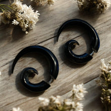 Load image into Gallery viewer, Black spiral earrings on a wooden surface with white flowers