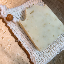 Load image into Gallery viewer, Bar soap resting on natural sisal soap saver pouch with wooden bead