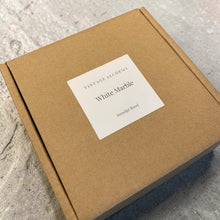 Load image into Gallery viewer, White Marble smudge bowl presented in a kraft gift box with minimalist Vintage Alchemy label on a warm neutral plaster background.
