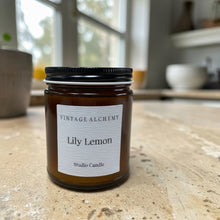 Load image into Gallery viewer, Vintage Alchemy Lily Lemon candle on a wooden surface with a blurred background
