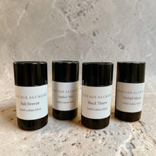 Load image into Gallery viewer, Four solid lotion stick containers from Vintage Alchemy on a textured surface with a neutral background.
