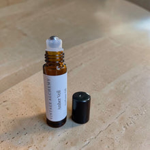 Load image into Gallery viewer, Amber Veil perfume oil roller with cap removed on warm limestone surface

