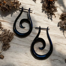 Load image into Gallery viewer, Black spiral earrings on a light wooden surface with dried flowers.
