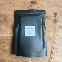 Load image into Gallery viewer, Botanical soy tealights Minted Sage in matte black pouch packaging on natural wood surface with dried botanical sprig
