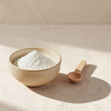 Load image into Gallery viewer, Fine coconut milk bath powder in warm ivory ceramic bowl with wooden scoop on soft neutral plaster surface
