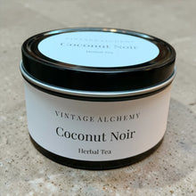 Load image into Gallery viewer, Tin of 'Coconut Noir' herbal tea from Vintage Alchemy on a textured surface
