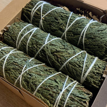 Load image into Gallery viewer, Eastern cedar smudge bundles in kraft gift box by Vintage Alchemy on light wood tabletop
