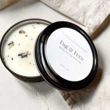 Load image into Gallery viewer, Black apothecary soy wax melt dish with botanical wax melts styled on soft neutral plaster surface for Vintage Alchemy Fog &amp; Fern fragrance.

