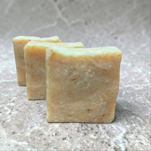 Load image into Gallery viewer, handmade exfoliating gardeners grit cold process soap with calendula on natural stone background
