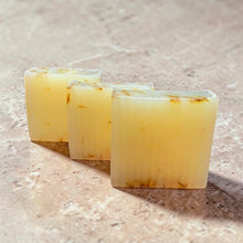 Load image into Gallery viewer, glycerin soap bars lined up grapefruit tangerine citrus soap with safflower petals on neutral stone background
