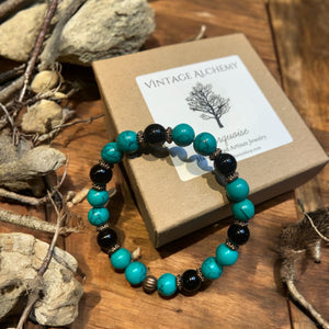 green turquoise and onyx beaded bracelet sitting on gift box