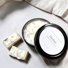 Load image into Gallery viewer, Black apothecary soy wax melt dish with botanical wax melts styled on soft neutral plaster surface for Vintage Alchemy Harbor fragrance.
