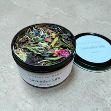 Load image into Gallery viewer, Open container of 'Lavender Silk' white tea with visible herbs and flowers on a neutral background
