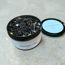 Load image into Gallery viewer, Open tea tin of 'Midnight Glen' black tea with visible tea leaves on a light surface.
