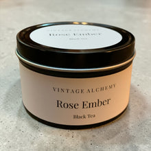 Load image into Gallery viewer, Rose Ember black tea in a labeled black tea tin with lid closed on a neutral stone surface.
