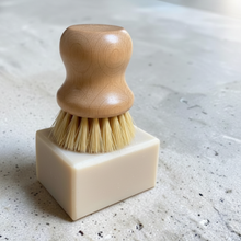Load image into Gallery viewer, Sprig solid dish soap with pumice and natural wood scrub brush on a light stone surface. Lavender, rosemary, and sage scented dish soap handcrafted by Vintage Alchemy.
