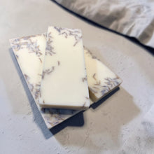 Load image into Gallery viewer, Botanical soy wax melt bars with dried lavender botanicals styled on soft gray plaster surface for Vintage Alchemy Uncharted fragrance.
