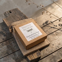 Load image into Gallery viewer, Vintage Alchemy handcrafted earrings gift box and linen pouch displayed on weathered wood with soft botanical background
