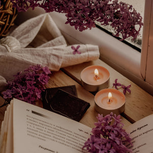 calming scene of books, candles, and lilacs